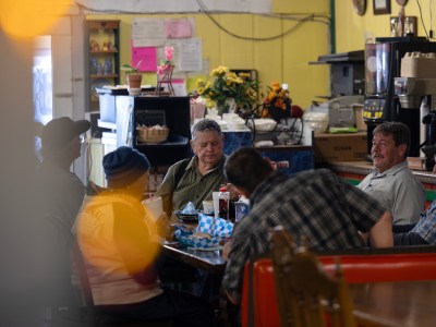 A small group gathers for lunch at Big Valley Market on Jan. 30. 2024. The market serves as the main grocer, restaurant and community gathering space for the town of Bieber. Photo by Miguel Gutierrez Jr., CalMatters